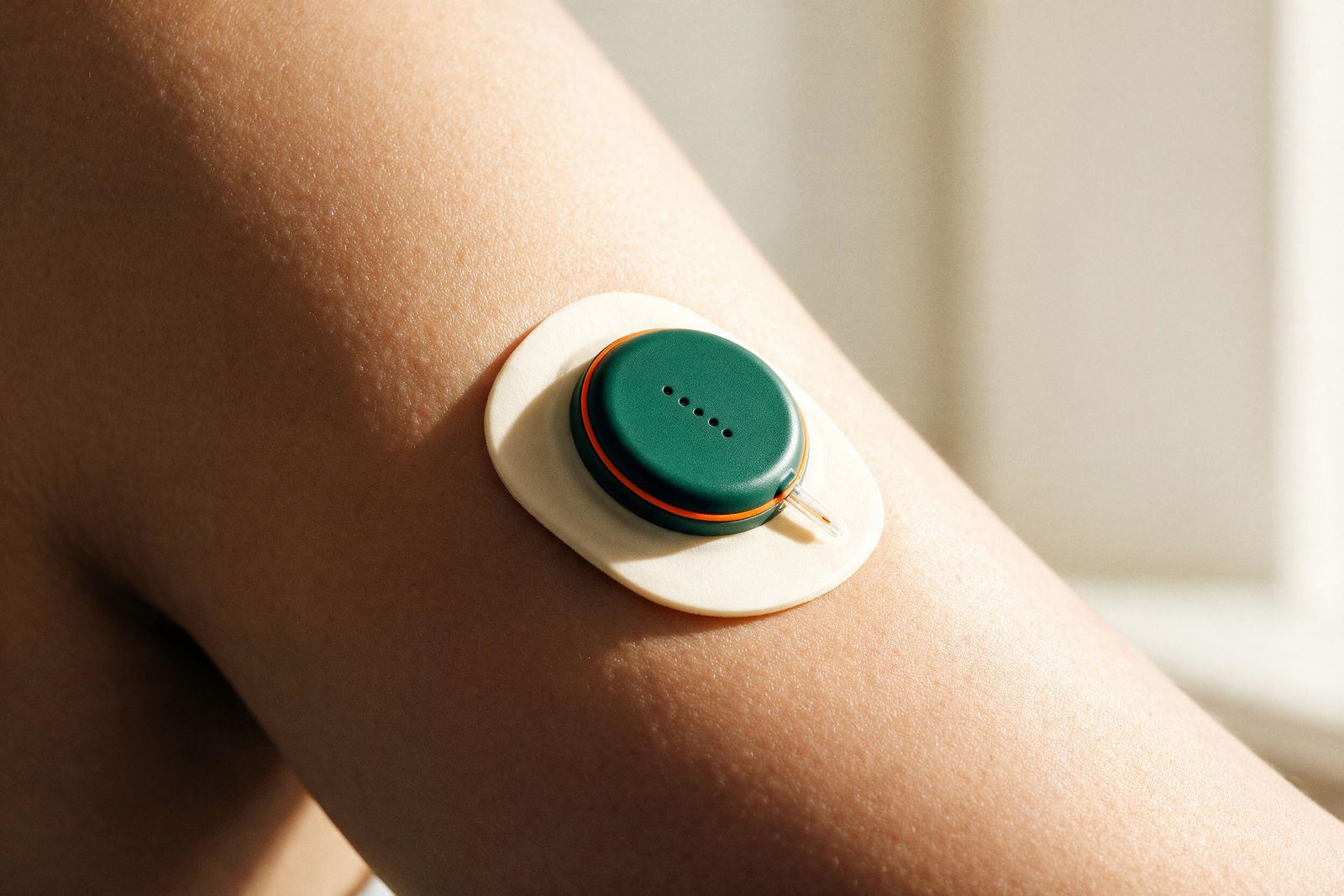 A continuous glucose monitor sensor worn on an upper arm.